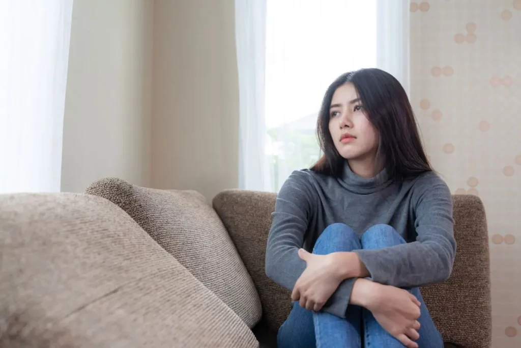 orang yang duduk di sofa sambil melamun