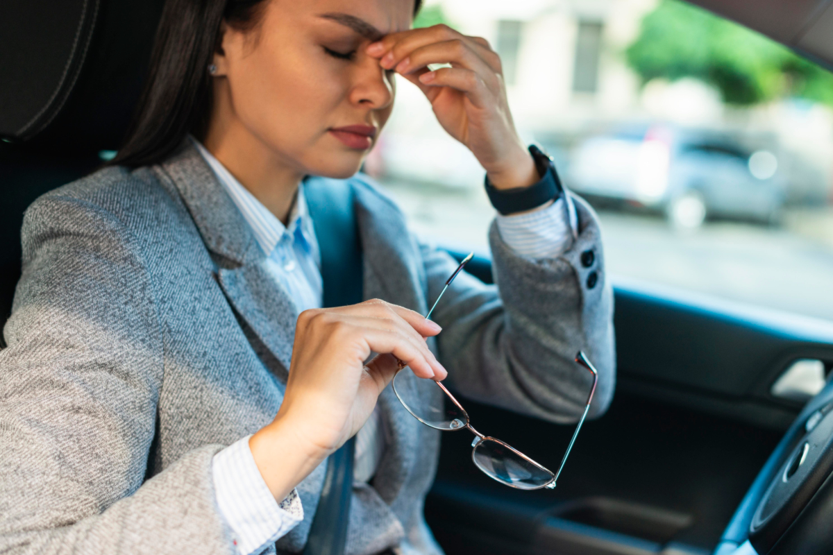 orang yang memegang hidung karena pusing di mobil 