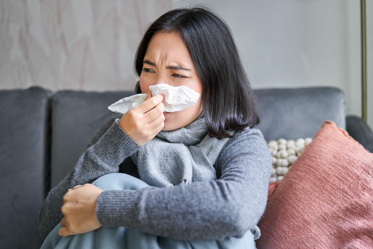 orang yang mengelap hidung dengan tisu